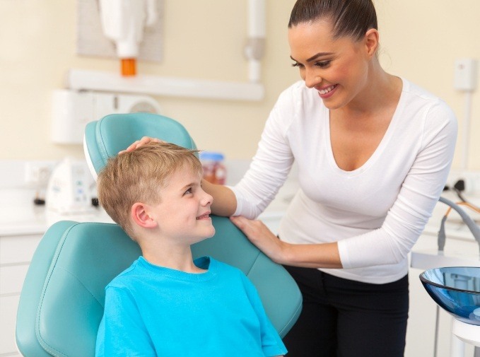 Dental team member smiling at young patient