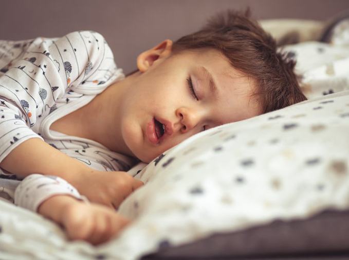 a child snoring while sleeping in bed