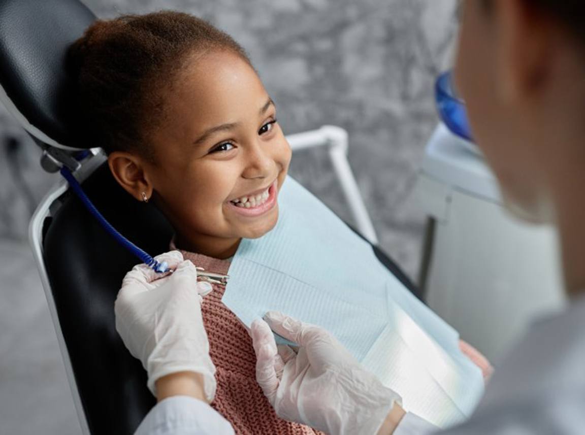 a child smiling while visiting her dentist
