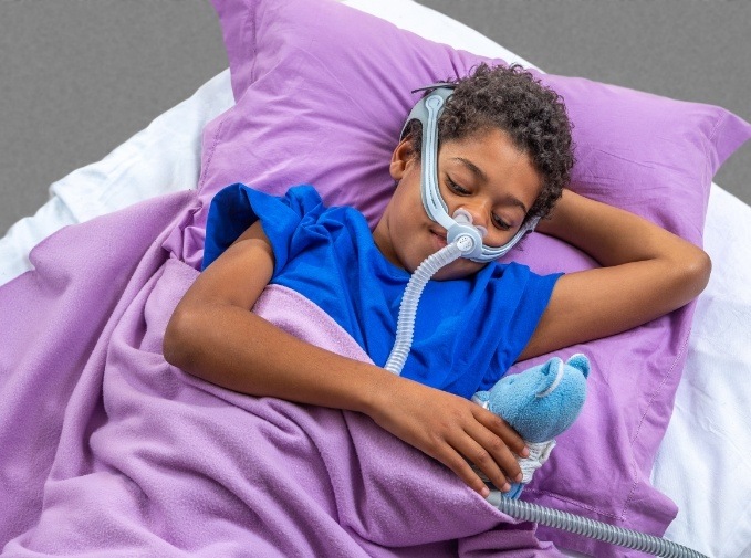 Child sleeping using sleep apnea treatment device
