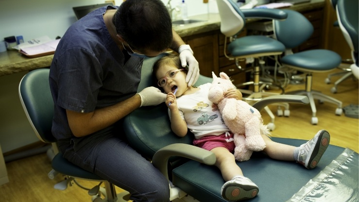 Pediatric dentist treating patient