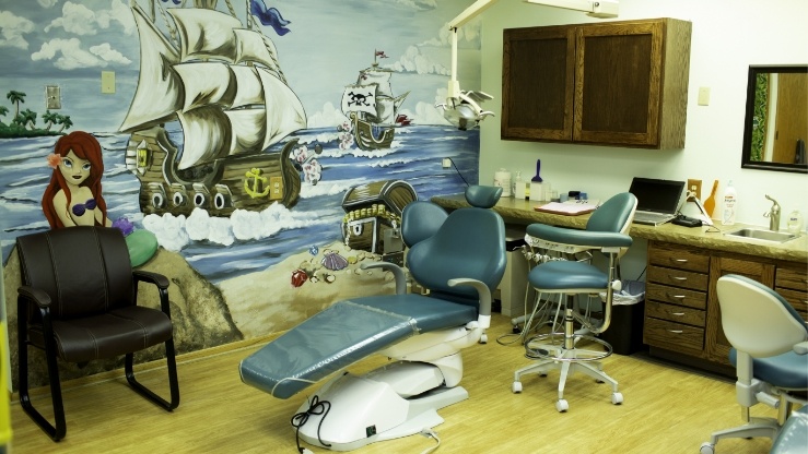 Dental treatment room with fun mural on wall