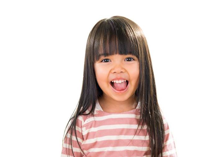 Portrait of happy little girl against white background