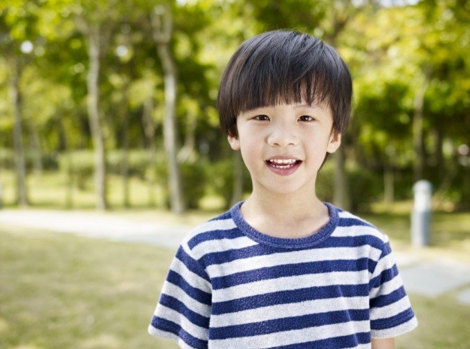 Child sharing healthy smile after soft tissue laser dentistry