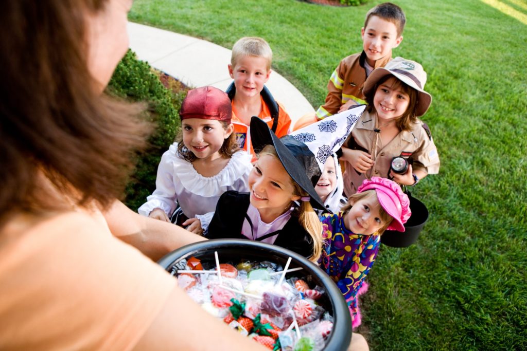 Group of children smiling while trick-or-treating on Halloween