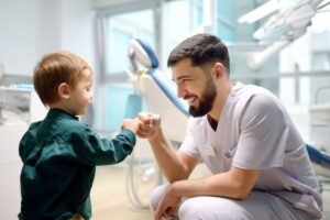 Small child giving a fist bump to his dentist 